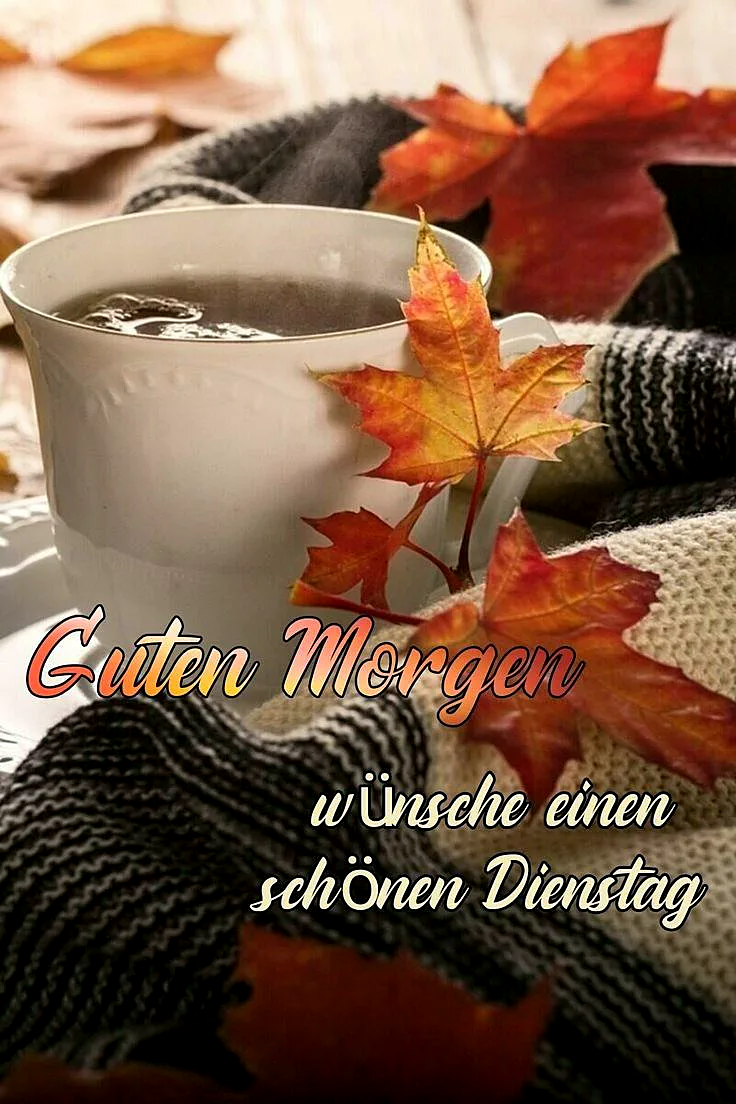 Eine dampfende Tasse Tee oder Kaffee, umgeben von leuchtenden Herbstblättern in Rot- und Orangetönen. Eine kuschelige Strickdecke im Hintergrund sorgt für eine warme, gemütliche Morgenstimmung und lädt zu einem fokussierten Dienstag ein.