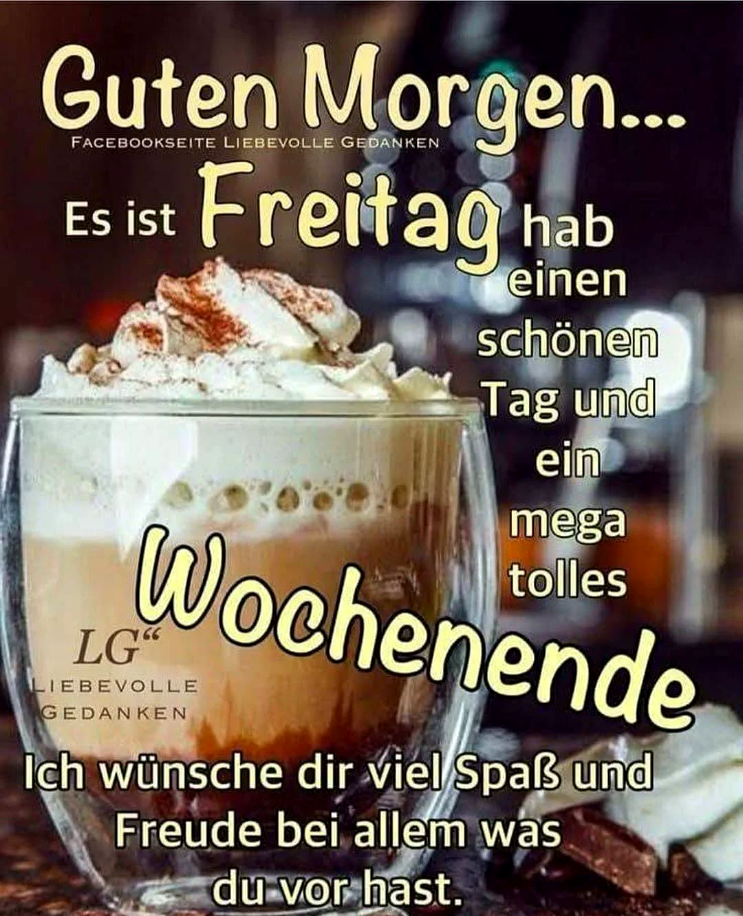 Ein Glas Kaffee mit Schaum und Zimt, im Hintergrund ein dunkler Raum mit Flaschen, ein Glas steht auf einem Tisch.
