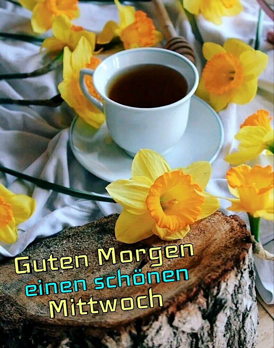Ein weißen Kaffeetasse mit Untertasse auf einem Baumstamm, umgeben von gelben Narzissen auf einem weißen Tuch.