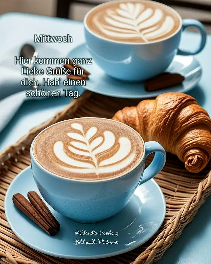 Zwei hellblaue Kaffeetassen mit kunstvoller Latte Art auf Untertassen, daneben ein goldbraunes Croissant und Zimtstangen. Alles arrangiert auf einem geflochtenen Tablett, bereit für einen gemütlichen Wochenmitte-Start.
