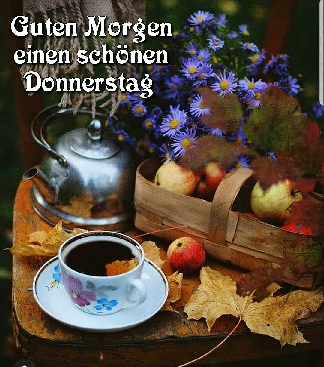 Ein idyllisches Stillleben mit einer blumengeschmückten Tasse Kaffee, einer glänzenden Teekanne, einem Korb voller Äpfel und herbstlichen Blättern auf einem rustikalen Holztisch, das Wärme und die Vorfreude auf das nahende Wochenende ausstrahlt.