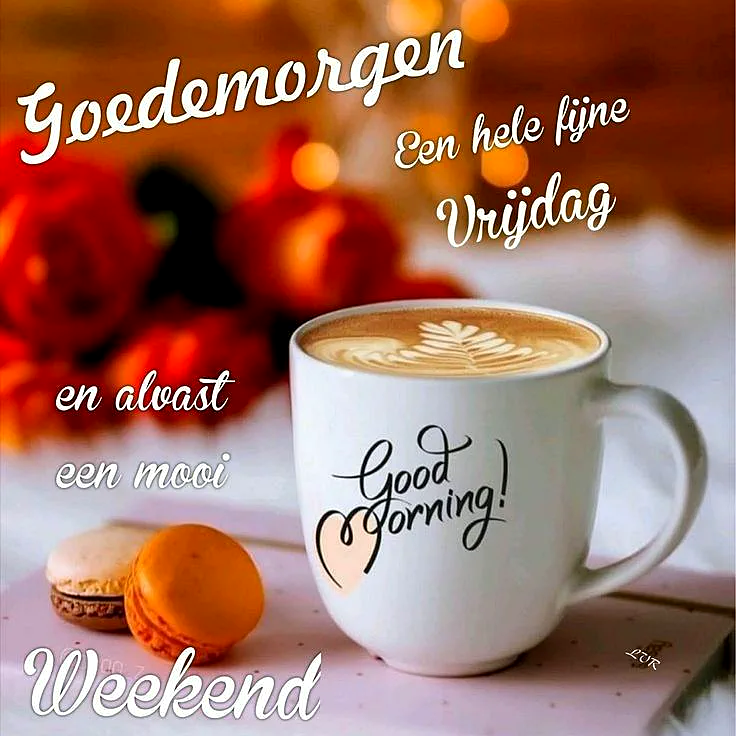 Ein weißer Kaffeebecher mit der Aufschrift 'Good Morning!' steht auf einem Tisch neben zwei Makronen, im Hintergrund unscharf rote Blumen und Lichter.