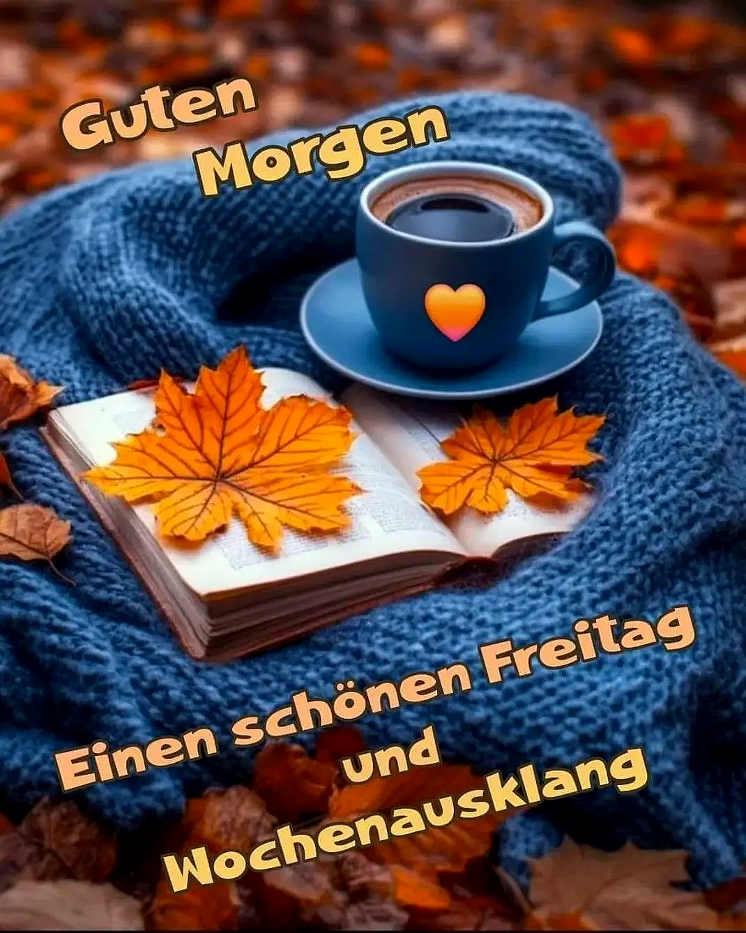 Ein blauer Kaffeebecher mit Herz auf einem blauen Pullover, daneben ein offenes Buch mit Herbstblättern, im Hintergrund viele Herbstblätter