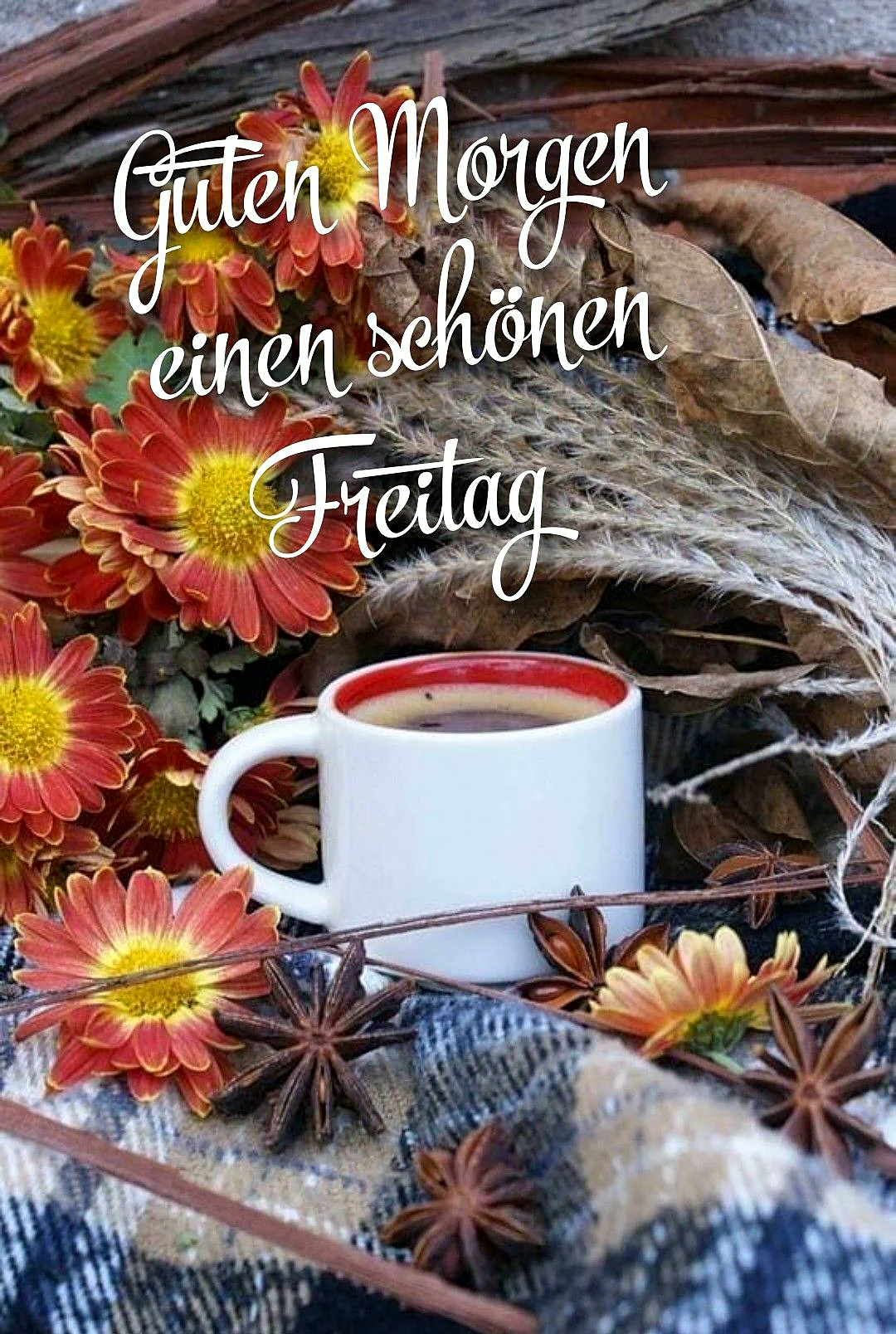 Ein weißer Kaffeebecher mit rotem Innenrand steht auf einem Tuch, umgeben von Sternanis, Blumen und Blättern.