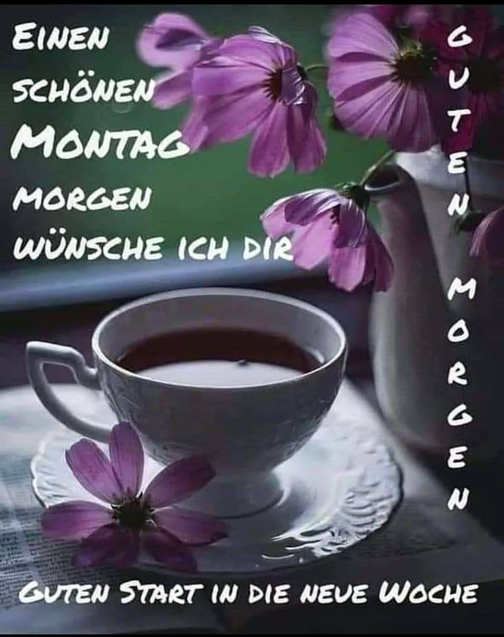 Ein weißer Kaffeebecher auf einer Untertasse mit einer Tasse Kaffee, umgeben von lila Blumen auf einem Tisch, im Hintergrund ein Blumenstrauß in einer Vase.