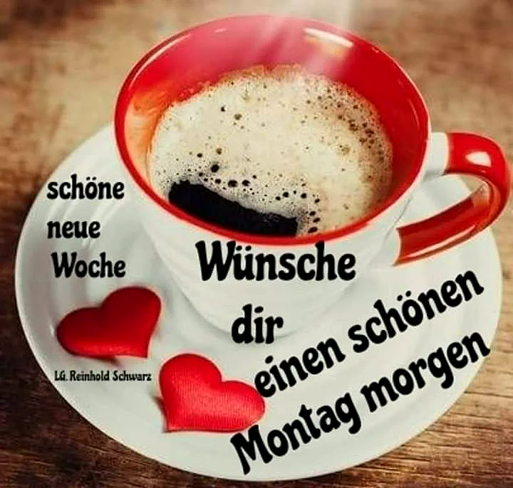 Ein roter Kaffeebecher auf einem weißen Teller mit zwei roten Herzen, Kaffee mit Schaum, auf einem Holztisch