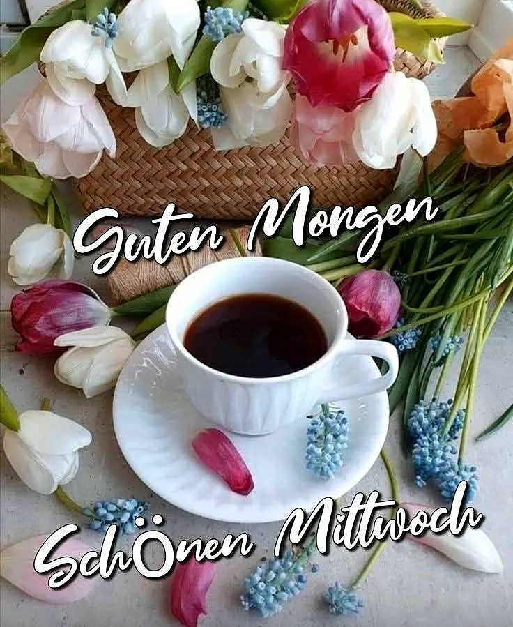 Eine weiße Kaffeetasse, umgeben von frischen weißen, rosa Tulpen und blauen Traubenhyazinthen, sendet einen gemütlichen Guten-Morgen-Gruß. Einzelne Blütenblätter auf der Untertasse verstärken die frühlingshafte, entspannte Mittwoch-Stimmung.