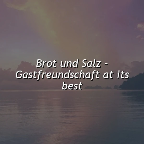 Ein ruhiges Meer bei Sonnenuntergang oder -aufgang mit fernen Inseln und einem sanften, farbigen Himmel. Der inspirierende Spruch "Brot und Salz – Gastfreundschaft at its best" steht in weißer, kursiver Schrift zentral im Bild, vermittelnd eine herzliche Atmosphäre.