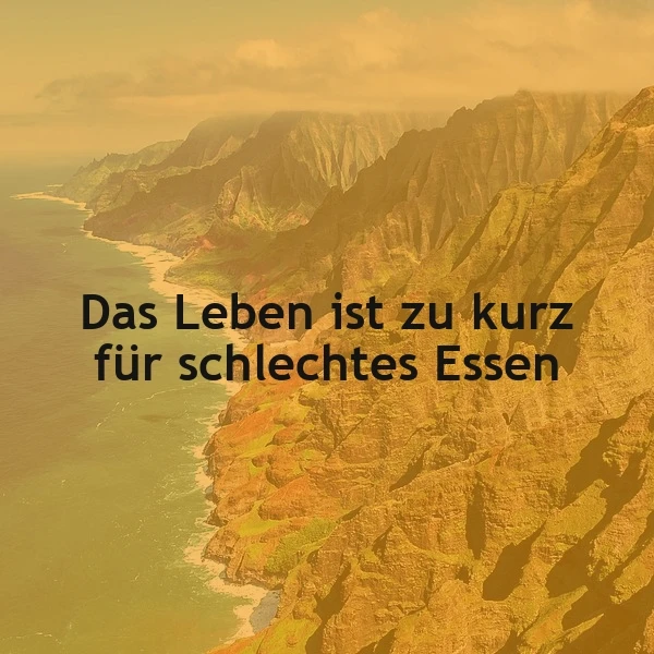 Malerische Küstenlandschaft mit goldenen Klippen und türkisblauem Meer unter warmem Himmel. Darauf der inspirierende Spruch: "Das Leben ist zu kurz für schlechtes Essen", der zum Genuss auffordert.