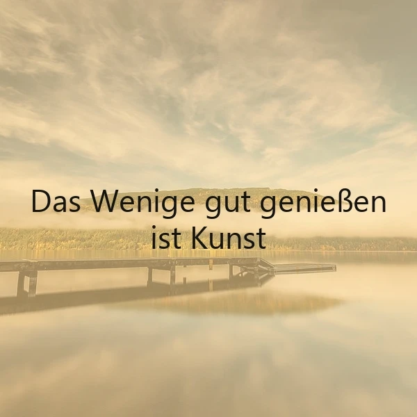 Ein ruhiger See mit einem Steg, der in den Hintergrund führt, umgeben von Bäumen und einem Himmel mit Wolken, auf dem der Spruch 'Das Wenige gut genießen ist Kunst' liegt.