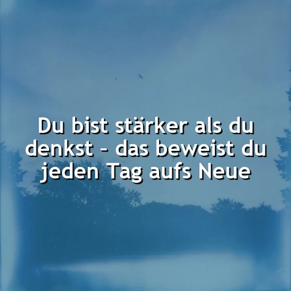 Blau getöntes Bild mit dem inspirierenden Spruch 'Du bist stärker als du denkst – das beweist du jeden Tag aufs Neue' in weißer Schrift. Der Hintergrund zeigt verschwommene Baumkonturen, die eine ruhige, stärkende Atmosphäre schaffen.
