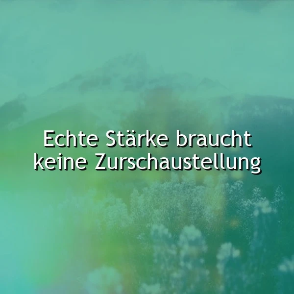 Ein inspirierendes Zitat auf einem mystischen Bergpanorama in grünen und aquamarinen Farbtönen. Der weiße Text lautet 'Echte Stärke braucht keine Zurschaustellung' und liegt über nebelverhangenen Baumwipfeln und Gipfeln. Die Atmosphäre wirkt ruhig und nachdenklich, mit einem weichen Licht. Ideal zum Teilen als Spruchbild.