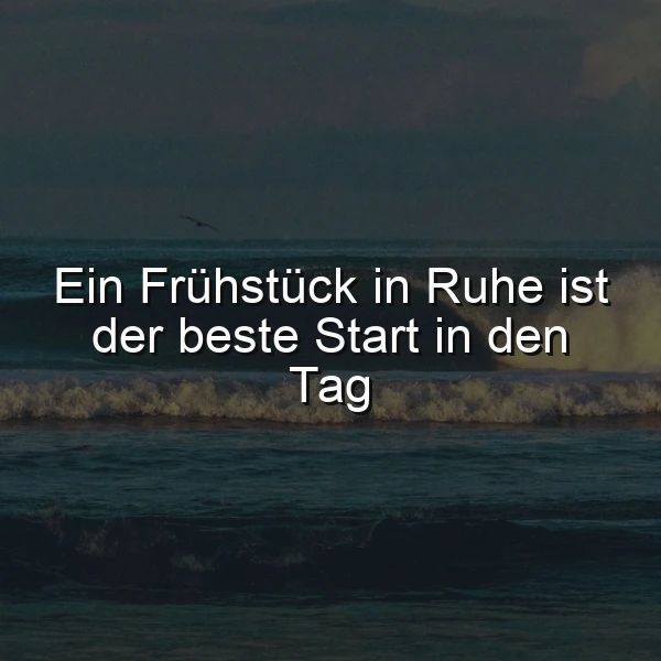 Ein dunkles Meer mit Wellen, ein Vogel fliegt am Himmel, im Vordergrund ein ruhiger Strand, das Zitat 'Ein Frühstück in Ruhe ist der beste Start in den Tag' in weißer Schrift