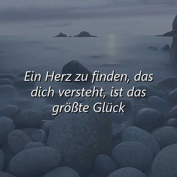 Ruhiges Bild mit dunklen Steinen im nebligen Wasser und dem Zitat 'Ein Herz zu finden, das dich versteht, ist das größte Glück'. Die morgendliche oder dämmrige Stimmung ist besinnlich und tiefsinnig.