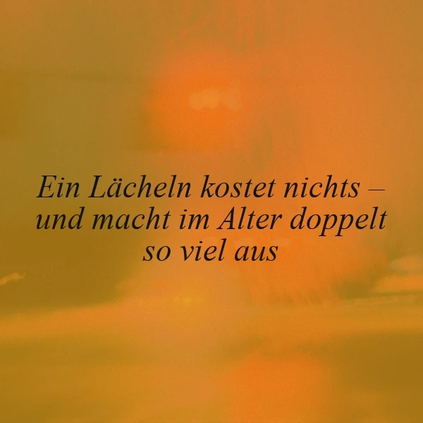 Warmes, golden-oranges Bild mit sanftem Licht. Zentral der Spruch: 'Ein Lächeln kostet nichts – und macht im Alter doppelt so viel aus.' Eine herzliche, tiefgründige Botschaft über die Wertschätzung einfacher Gesten im Laufe des Lebens.