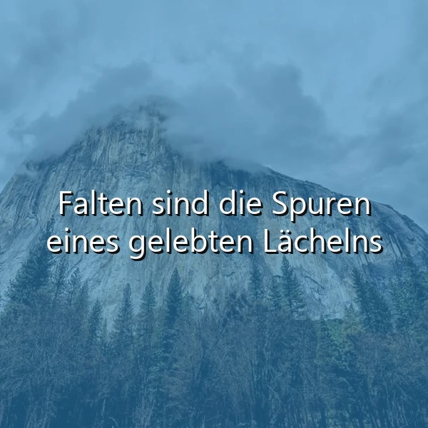 Ein majestätischer Berg, teilweise in Wolken gehüllt, erhebt sich über einem dunklen Tannenwald, darunter der weiße Text: "Falten sind die Spuren eines gelebten Lächelns", vermittelnd eine nachdenkliche und ruhige Stimmung.