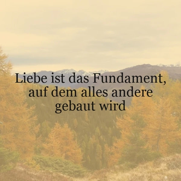 Ein Foto von einem Wald im Herbst mit gelben Blättern und einem Berg im Hintergrund. Der Text 'Liebe ist das Fundament, auf dem alles andere gebaut wird' ist über das Bild gelegt.