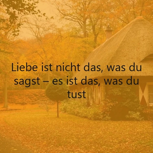 Goldenes Herbstbild mit einem reetgedeckten Haus und leuchtenden Bäumen. Auf dem Bild steht der Spruch: „Liebe ist nicht das, was du sagst – es ist das, was du tust.“ Eine nachdenkliche, warme Atmosphäre.