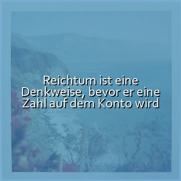 Ruhige, neblige Berglandschaft mit Wasser in Blaugrau. Dezente rote Pflanzen im Vordergrund. Der weiße Spruch 'Reichtum ist eine Denkweise, bevor er eine Zahl auf dem Konto wird' regt zum Nachdenken an.