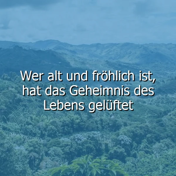 Malerische Berglandschaft in verschiedenen Grüntönen unter sanft blauem Himmel. Darauf der weiße Text „Wer alt und fröhlich ist, hat das Geheimnis des Lebens gelüftet.“ Eine ruhige Naturansicht, die zur Besinnung einlädt und zum Nachdenken anregt.