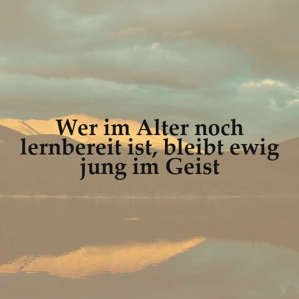 Ein ruhiger See mit Bergen im Hintergrund während eines Sonnenuntergangs. Der Text 'Wer im Alter noch lernbereit ist, bleibt ewig jung im Geist' ist über das Bild gelegt.